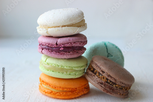Fototapeta Naklejka Na Ścianę i Meble -  Colorful French or Italian macaroon stack cakes / Macaroon cakes. Assorted macaroon cakes stacked on top of each other on a light background. Copy space. Delicious dessert.