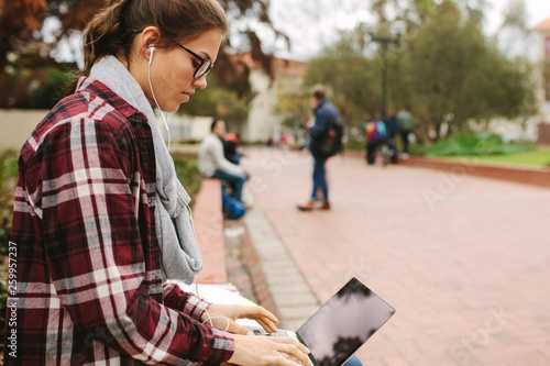 Female college student using laptop at campus