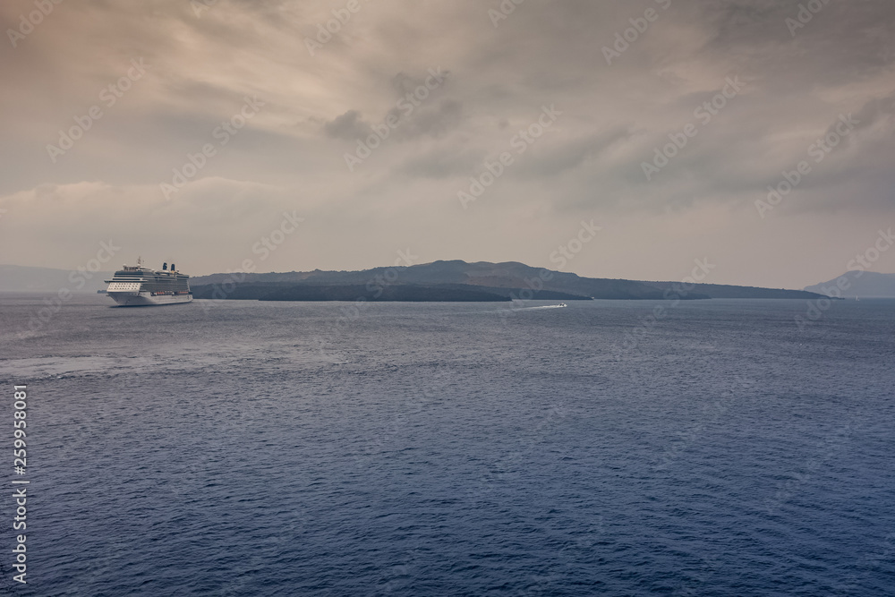 Panorama of Santorini on a cloudy day, with cruise ship waiting in the harbor Panorama of Santorini on a cloudy day, with cruise ship waiting in the harbor