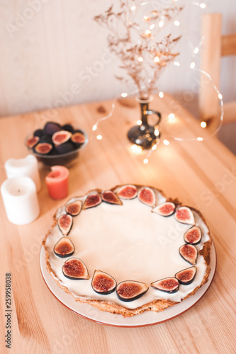 Tasty cake with fresh fig fruit staying on wooden table in room closeup.
