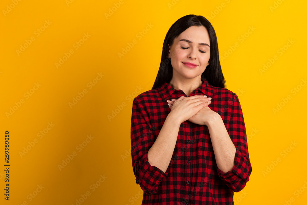Closeup photo beautiful her she lady long hair sweet hold hands hands close heart chest full of emotions emotions wear specifications casual red shirt isolated yellow background Closeup photo beautiful her she lady long hair sweet hold hands hands close heart chest full of emotions emotions wear specifications casual red shirt isolated yellow background
