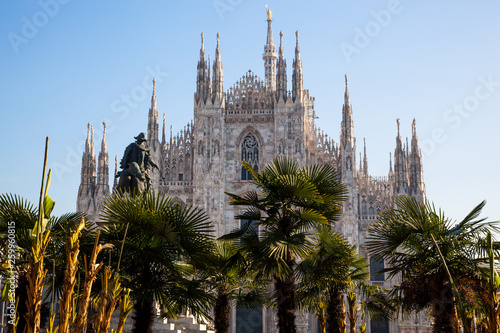 View of the Duomo cathedral of Milan and palm trees on a sunny day and tourists © dante1969