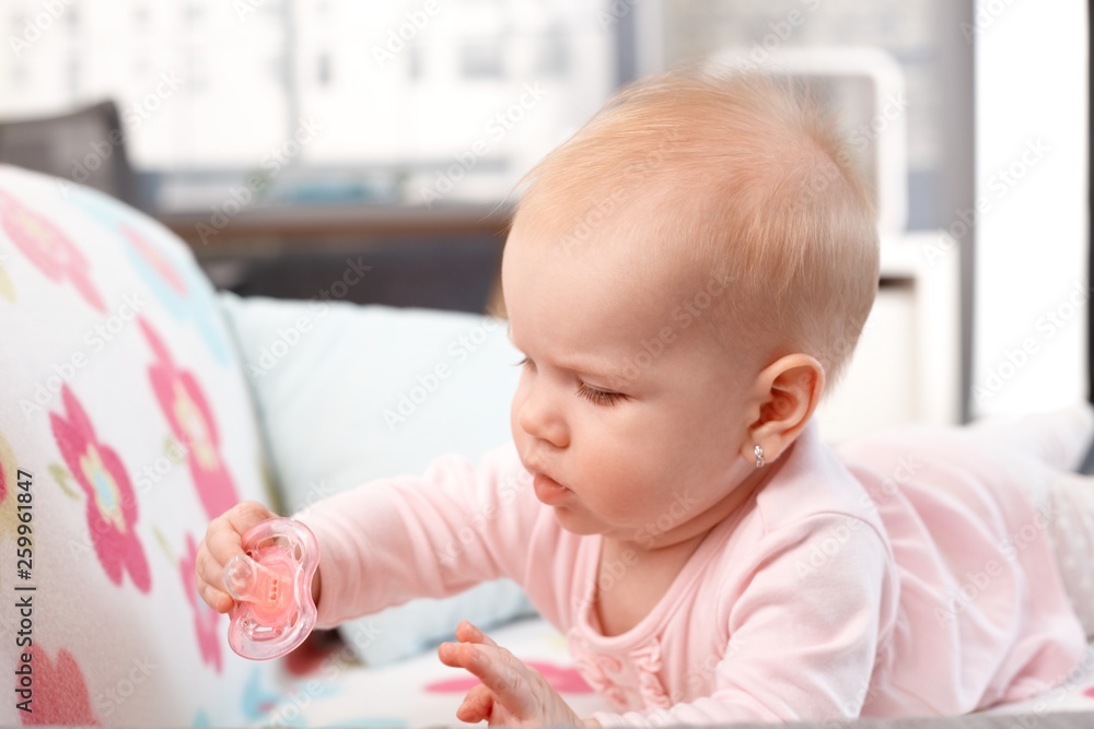 Baby girl playing with dummy at home Baby girl playing with dummy at home
