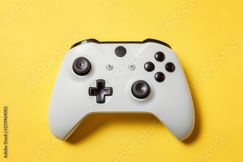 White joystick gamepad, game console on yellow colourful trendy modern fashion pin-up background. Computer gaming competition videogame control confrontation concept. Cyberspace symbol