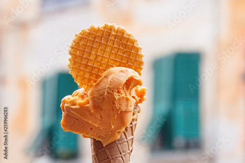orange ice cream and wafer on background of Italian house in Cinque-Terre © ksenija1803z