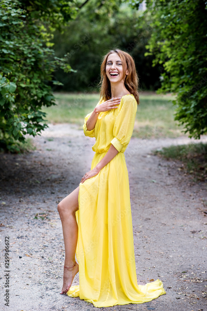 Incredible beautiful dancer in a long yellow dress. Fashion and beauty dancer. A girl in a yellow dress is dancing in a flowered park. Incredible beautiful dancer in a long yellow dress. Fashion and beauty dancer. A girl in a yellow dress is dancing in a flowered park.