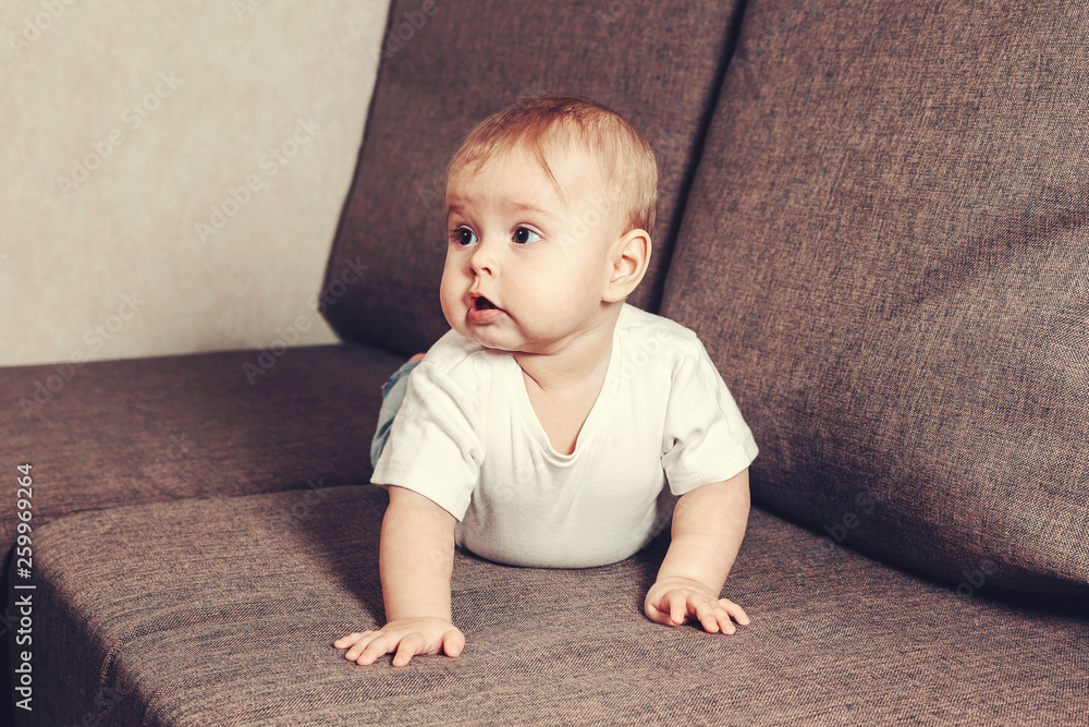 Little baby crawls on the bed. The child learns the world.