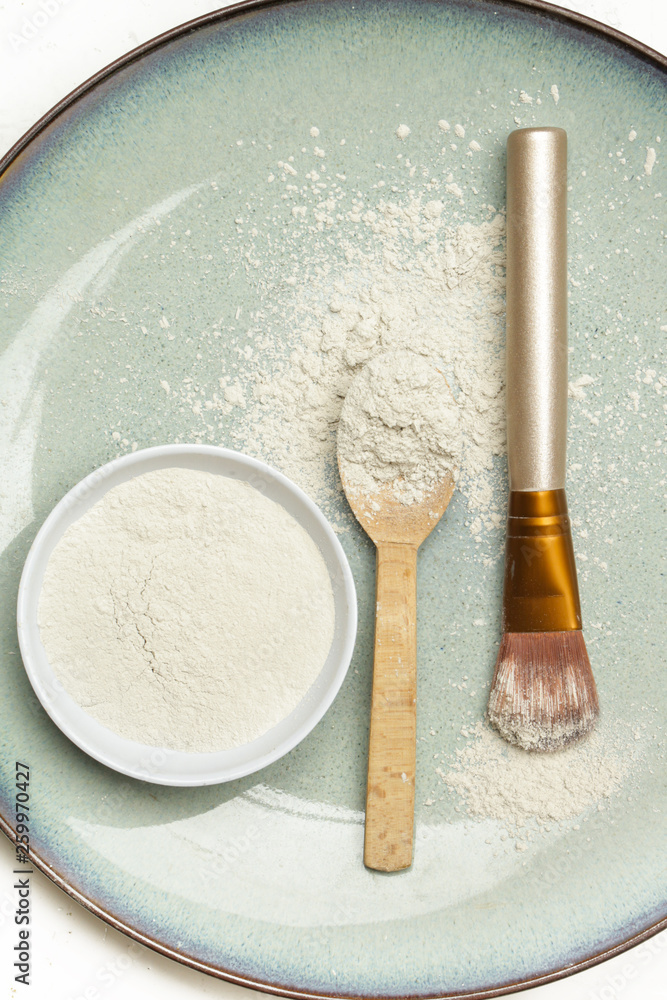 Top view of cosmetic clay powder in a bowl with a spoon and cosmetic brush Top view of cosmetic clay powder in a bowl with a spoon and cosmetic brush