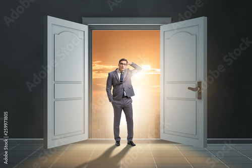 Puzzled businessman in front of big door