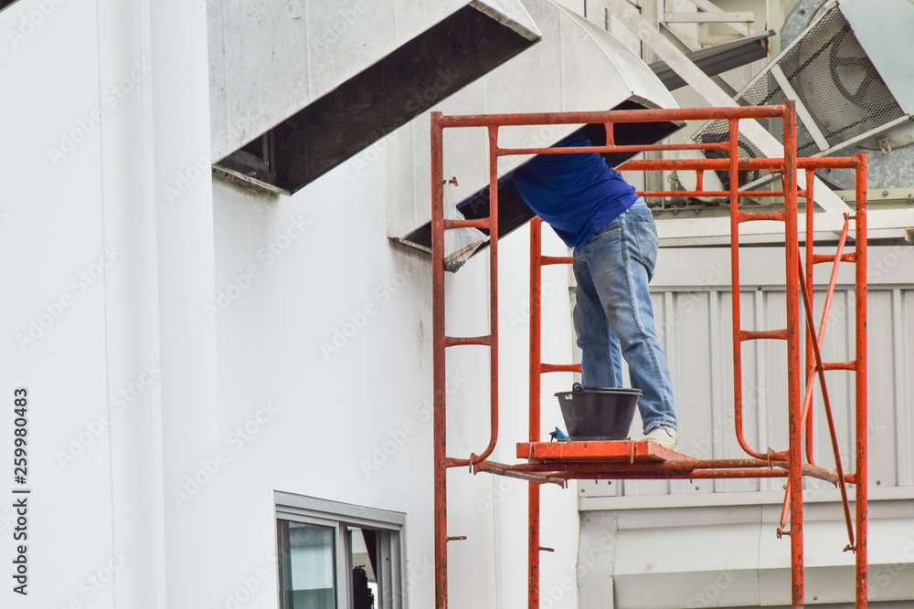 Man standing on steel scaffolding for cleaning duct and ventilation system in factory site. Man standing on steel scaffolding for cleaning duct and ventilation system in factory site.