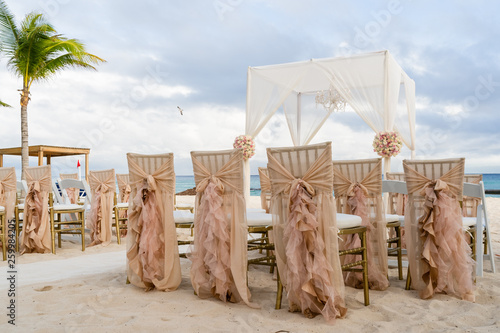 Vintage Dekoration einer Hochzeit mit Stuehlen am Strand mit Meer im HIntergrund