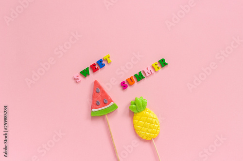 Sweet summer text, Pineapple and watermelon lollipops on pink background. Concept Summer vacation or holidays Creative Top view Template Greeting card, postcard