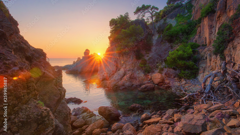 Colorful sunrise on sea bay in mediterranean. Morning Sea nature landscape with bright sun. Spanish coast in sunlight