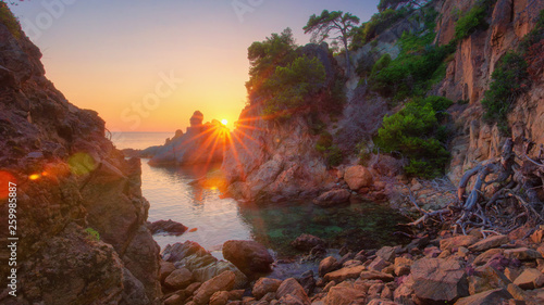 Colorful sunrise on sea bay in mediterranean. Morning Sea nature landscape with bright sun. Spanish coast in sunlight