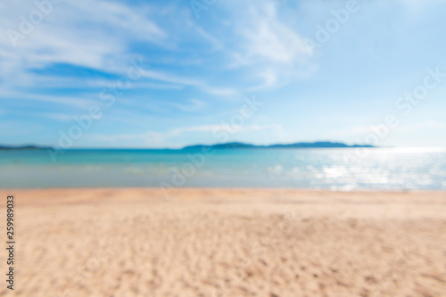 Abstract background blurry scenic of summer sand beach and cloudy blue sky