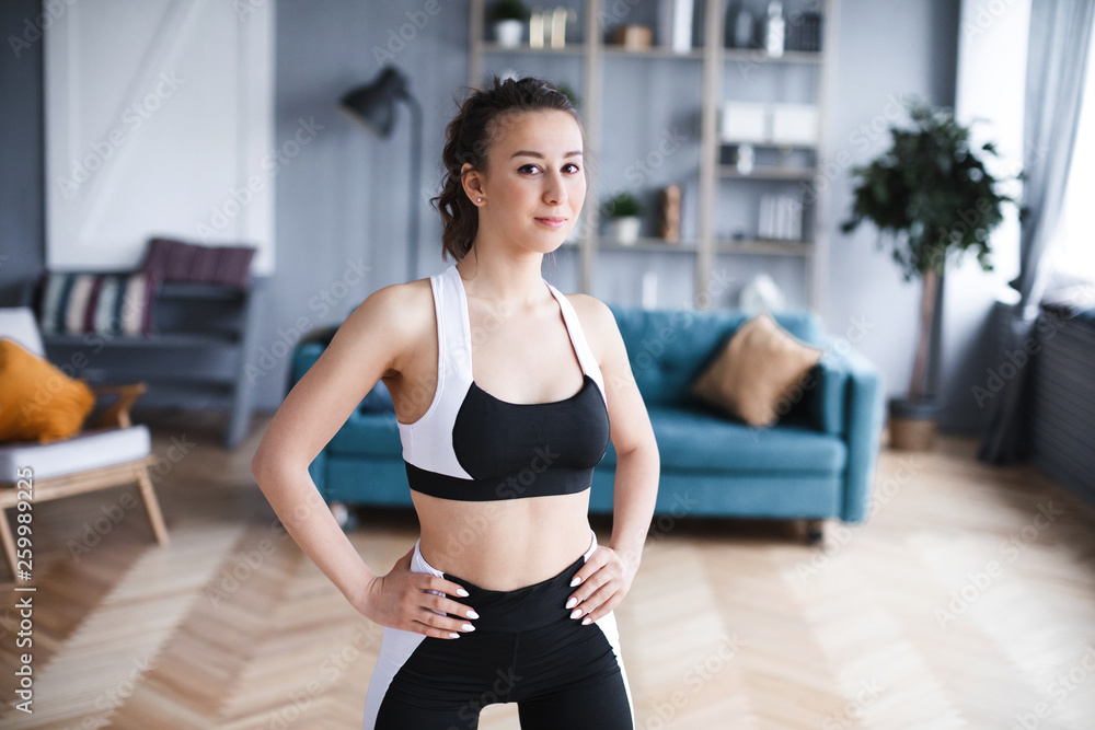 Portrait of a sports woman in the living room at home. Portrait of a sports woman in the living room at home.