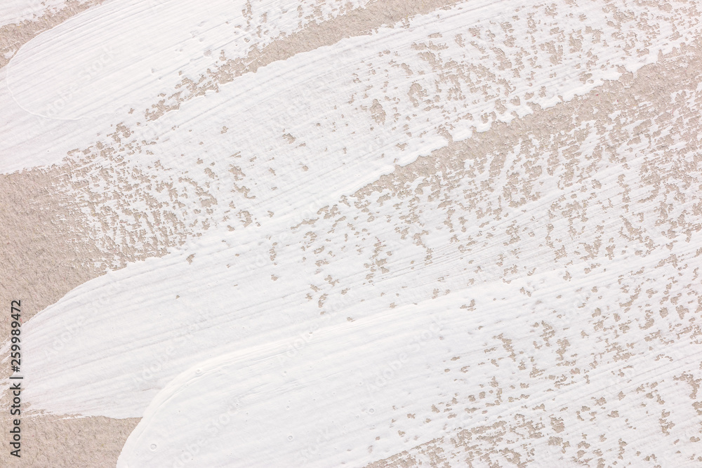 Obraz premium abstract white brush strokes of paint on gray paper. closeup view