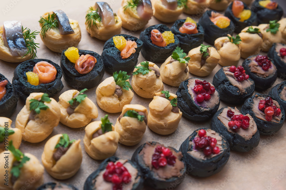Tasty and juicy snacks for buffet table: mini burgers, canapés, fruit, sliced and baked Tasty and juicy snacks for buffet table: mini burgers, canapés, fruit, sliced and baked