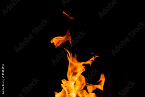 Fire isolated on black background. Isolated flame. Bright orange fire. Burning flame. Flames background. Fiery orange texture. Close up fire energy and motion.