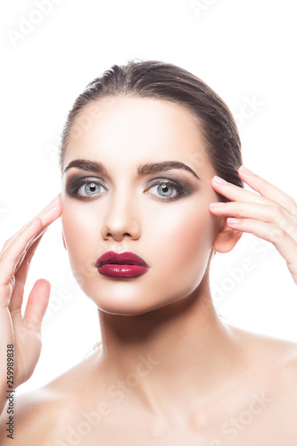 Fashion model woman beauty portrait. Bright red lips makeup, perfect fresh clean skin. smokey eye shadows. Hands near face. Skincare facial treatment concept. White background