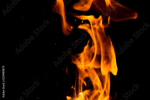 Fire isolated on black background. Isolated flame. Bright orange fire. Burning flame. Flames background. Fiery orange texture. Close up fire energy and motion.