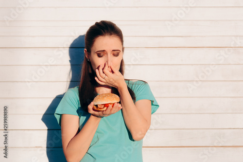 Quadro em tela Woman Holding a Stinky and Disgusting Burger