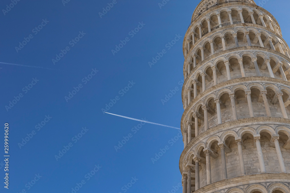 Pisa tower landmark on a solid blue sky with airplane flying on the background
