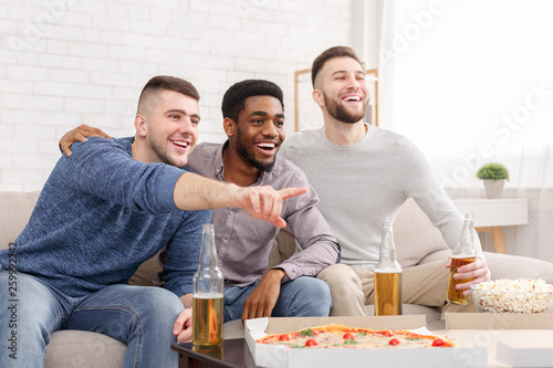 Look. Man pointing on tv, watching soccer with friends
