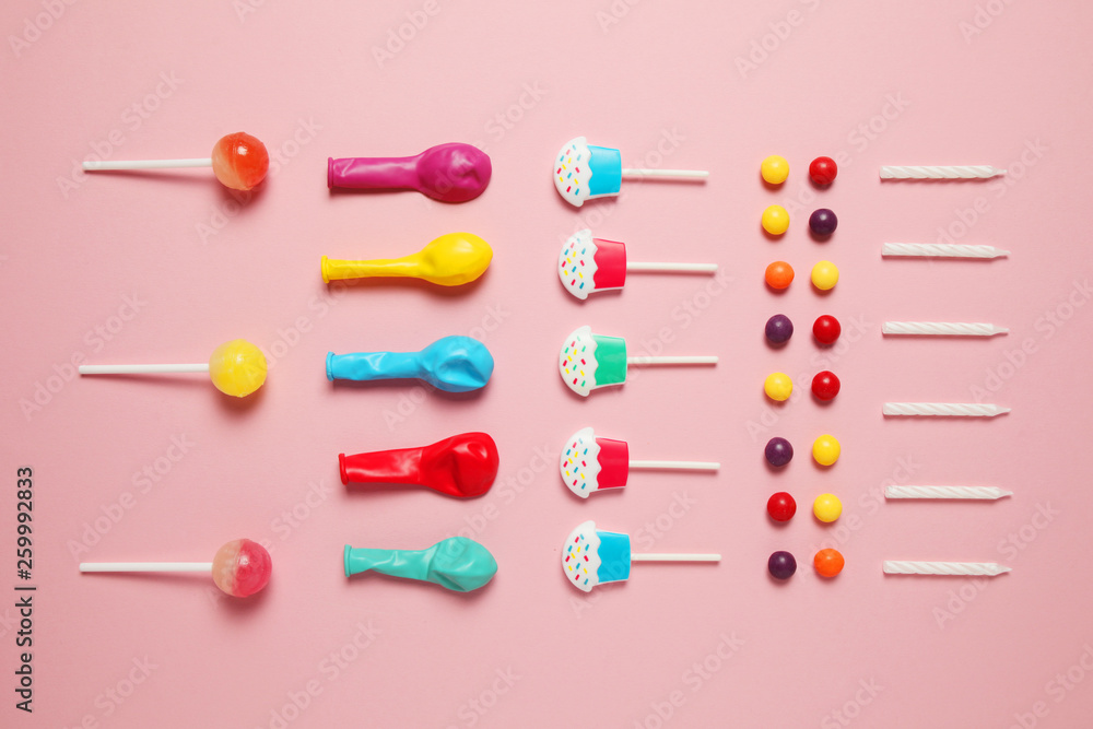 Children's cheerful decor for a party, pink background. Sweet candies, bright balls, festive candles and straws. Children's cheerful decor for a party, pink background. Sweet candies, bright balls, festive candles and straws.