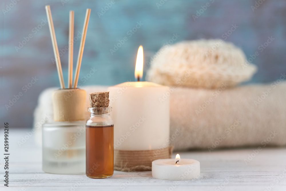 Towels, candle and massage oil on white table Towels, candle and massage oil on white table