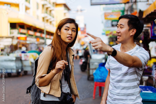 фотографія Young female tourist asking for directions and help from local people in Bangkok