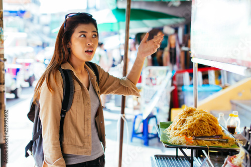 Young Asian woman tourist getting scammed and unhappy with overpriced street food in Thailand
