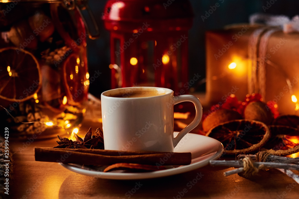 Cup of coffee in festive decorations with a fairy garland lights