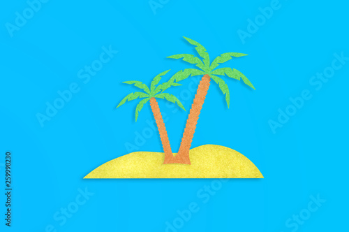 Two palm trees with leaves and yellow island cut out from paper on blue table. Top view. Minimalism concept - Image photo