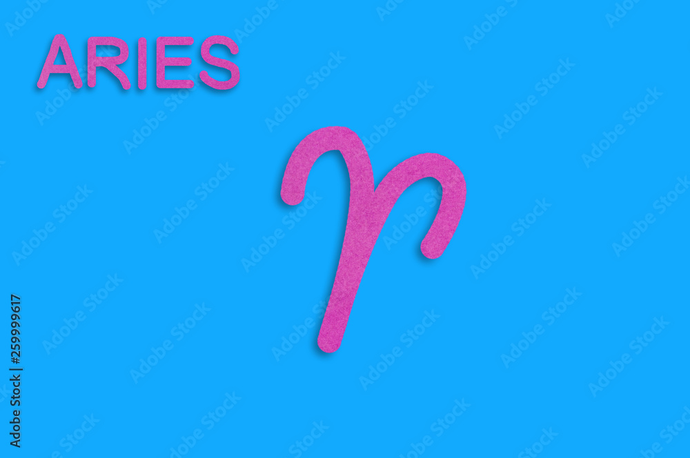 Symbol of astrological sign and word aries cut out of purple paper on blue table. Top view. Horoscope concept Symbol of astrological sign and word aries cut out of purple paper on blue table. Top view. Horoscope concept