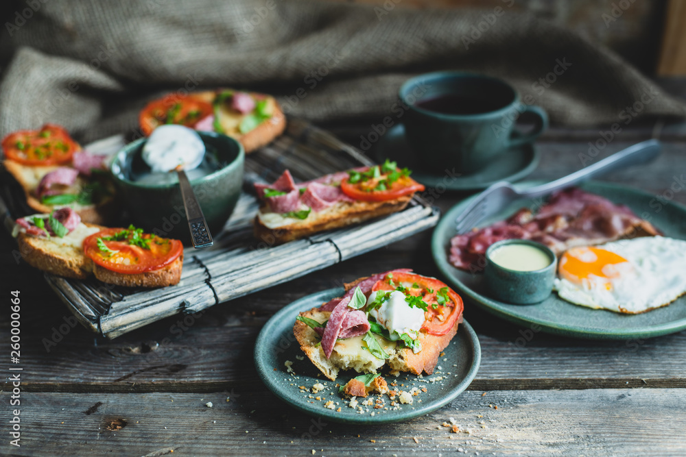 rustic breakfast, baked with basil, tomato, salami and cheese slices of bread, fried egg and bacon rustic breakfast, baked with basil, tomato, salami and cheese slices of bread, fried egg and bacon