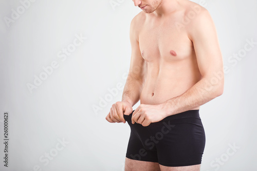 Photos A man in underwear is looking down.