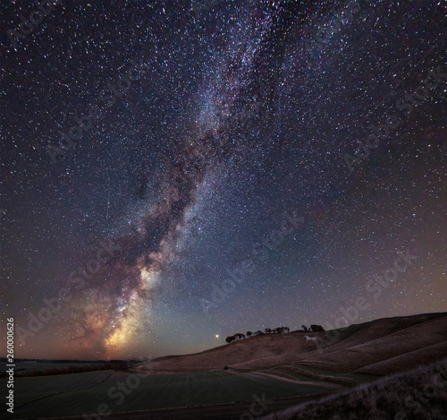 Vibrant Milky Way composite image over landscape of ancient chalk white horse at Cherhill in Wiltshire