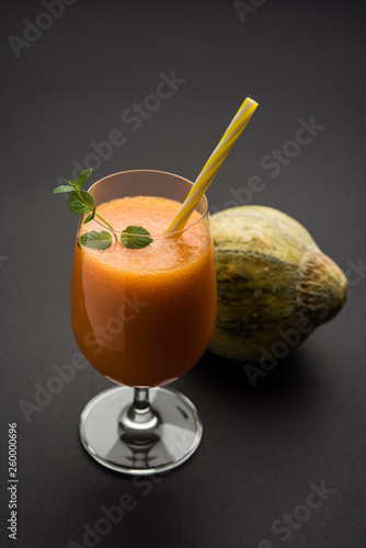 Musk melon juice with slice, also known as Kharbuj/kharbuja fruit extract, served in a glass with mint. selective focus photo