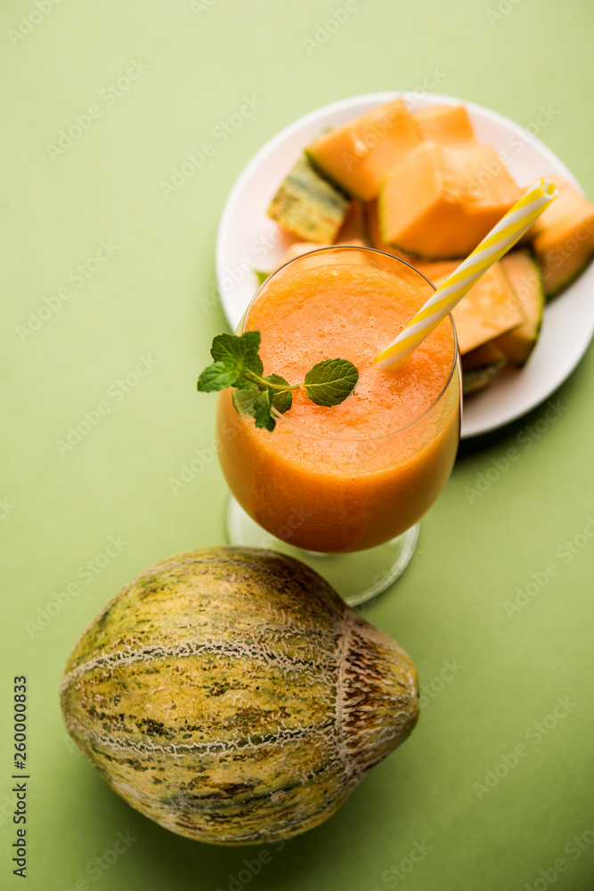 Musk melon juice with slice, also known as Kharbuj/kharbuja fruit extract, served in a glass with mint. selective focus