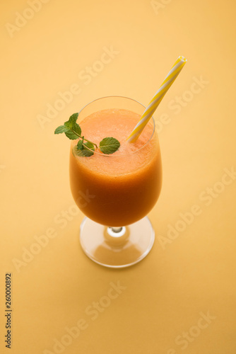 Musk melon juice with slice, also known as Kharbuj/kharbuja fruit extract, served in a glass with mint. selective focus photo