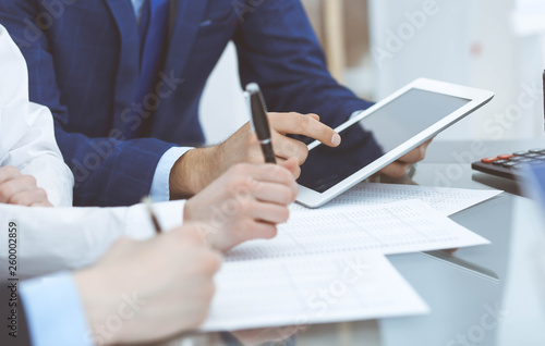 Businessman using laptop at meeting, closeup of hands. Business operations concept