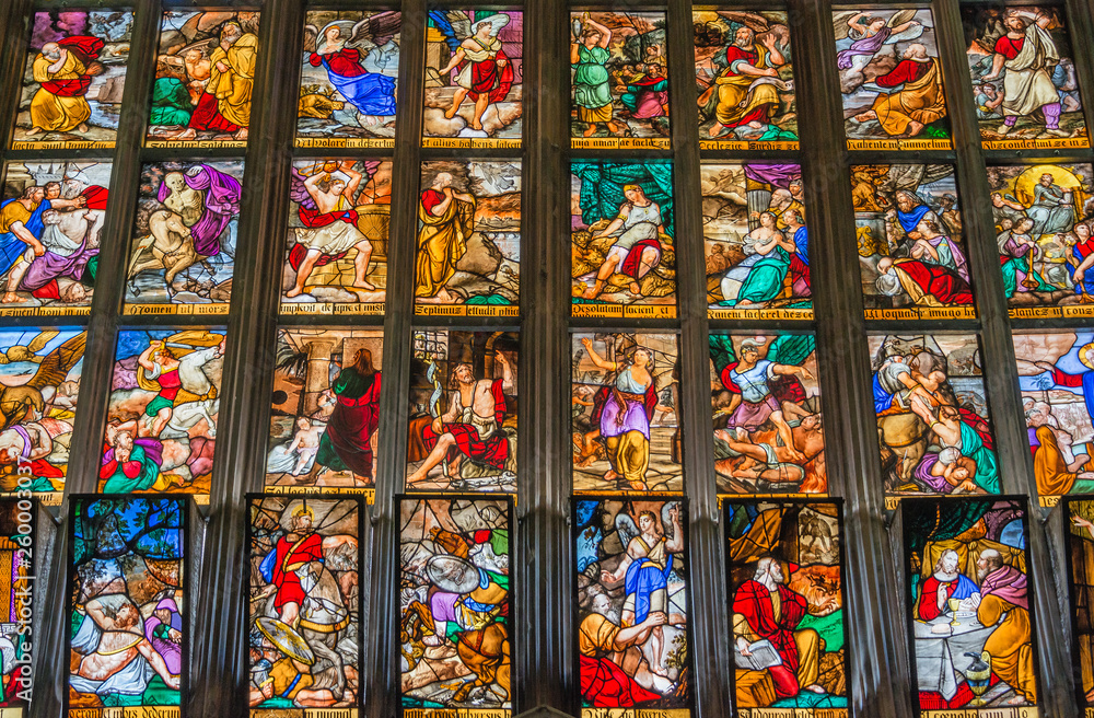 Window view with colorful glass depicting biblical scenes at magnificent Cathedral of Milano, Milan, Italy