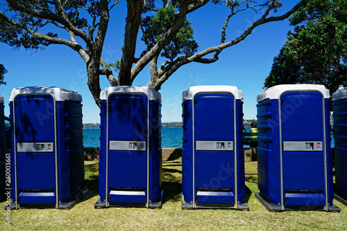 A row of blue toilet cubicles at an outdoor event. photo