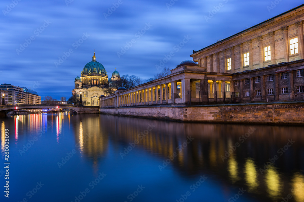 Beautiful view of illuminated Berliner Dom (Berlin Cathedral) and Alte Nationalgalerie on Museum Island and reflections on the Spree River in Berlin, Germany, at dusk.