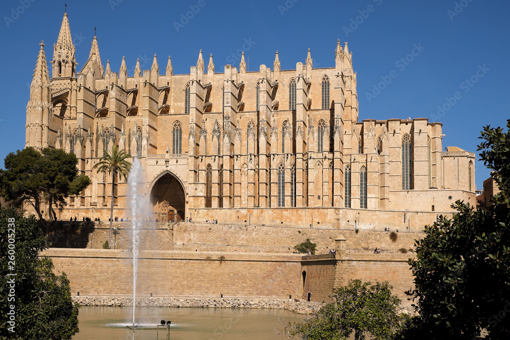 Palma de Mallorca, Spain, side view of the famous gothic cathedral Santa Maria La Seu with water fountain in the foreground Palma de Mallorca, Spain, side view of the famous gothic cathedral Santa Maria La Seu with water fountain in the foreground