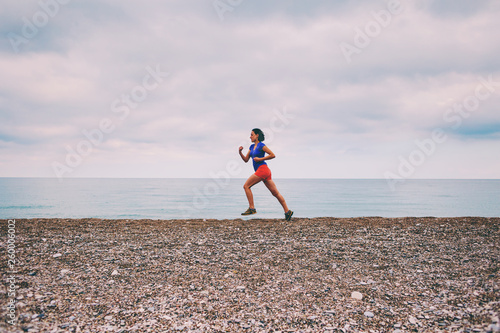 The girl runs along the sandy beach.