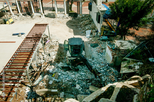 hydraulic hammer destroys asphalt and the surrounding area of the old building photo