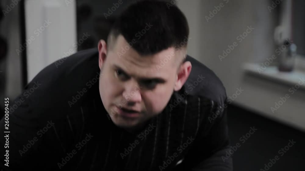 Cheerful fat man performs a wrong exercise in the gym. For the first time in a fitness club. Cheerful fat man performs a wrong exercise in the gym. For the first time in a fitness club.