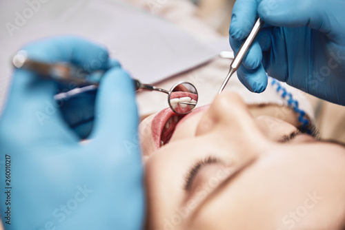 Advanced Medicine, Trusted Care. Attractive woman at the dental office. Dentist examining patient's teeth in clinic.